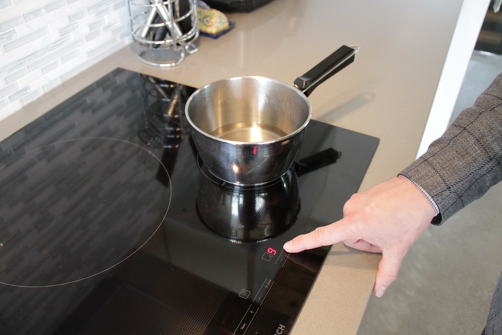 Person turning on induction stovetop.